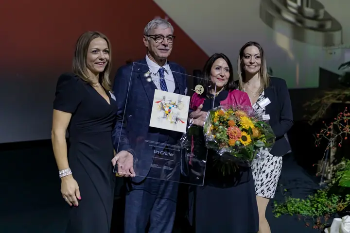 Urs Grütter mit Familie und der Auszeichnung auf der Bühne