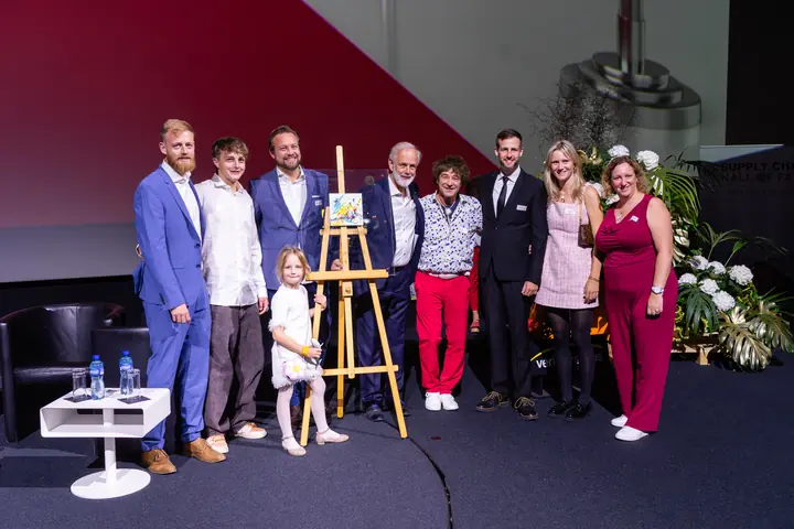 Die Familie Richner mit Gästen und der Urkunde auf der Bühne