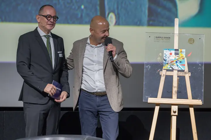 Nils Planzer mit Laudator Dr. Josef Felder und der Auszeichnung auf der Bühne