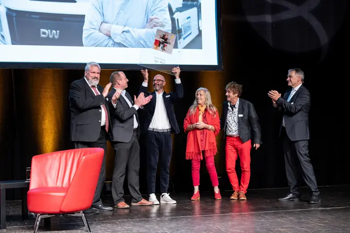 Tobias Wülser mit Laudator Michael Künzle und Gästen auf der Bühne der Benefizgala 2025